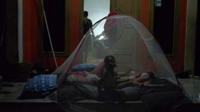 TIDUR DI TERAS - Anak-anak Suprapti terpaksa tidur di teras rumahnya di Gampong Jeulingke, Kecamatan Syiah Kuala, Banda Aceh, Selasa (30/9/2025) malam.