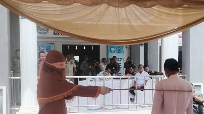 Eksekutor hukuman cambuk mengayunkan rotan ke punggung pelanggar syariat Islam di Aceh Timur, Rabu (8/10/2025).