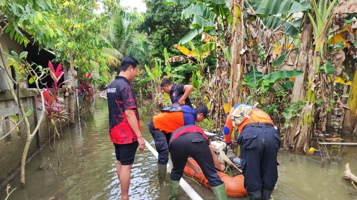 TANGANI BANJIR - Petugas BPBD Karangasem tetap berupaya menyedot air yang masih menggenang rumah warga di Dusun Tengading, Desa Antiga, Selasa (30/9).