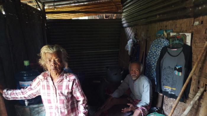 TINGGAL DI GUBUK - Kakak beradik lanjut usia (lansia) Ngadiyem dan Tukimin saat ditemui di gubuk yang menjadi tempat tinggal mereka di Desa Bangsa, Kecamatan Kebasen, Kabupaten Banyumas, Jawa Tengah, Rabu (1/10/2025). Keduanya hidup di gubuk berdinding anyaman bambu yang mulai keropos, berlantai tanah, dan atap yang berlubang.