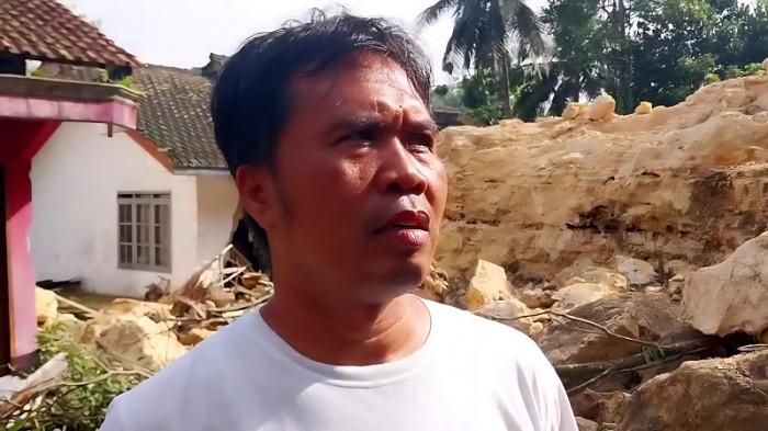 KORBAN LONGSOR -  Erwin menceritakan detik-detik longsor bukit kapur yang nyaris merenggut keselamatan keluarganya di Desa Darmakradenan, Kecamatan Ajibarang, Kabupaten Banyumas, Senin (27/10/2025). Longsor yanga terjadi Minggu (26/10/2025) sore itu mengakibatkan satu rumah rata dan dua rumah rusak berat.