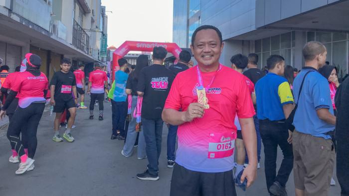 FUN RUN -- Ketua DPRD Kota Gorontalo, Irwan Hunawa menunjukkan medali Smartfren Fun Run Gorontalo, Minggu (4/8/2025). Irwan memuji antusiasme masyarakat Gorontalo. (Sumber Foto: TribunGorontalo.com/Jefri Potabuga)