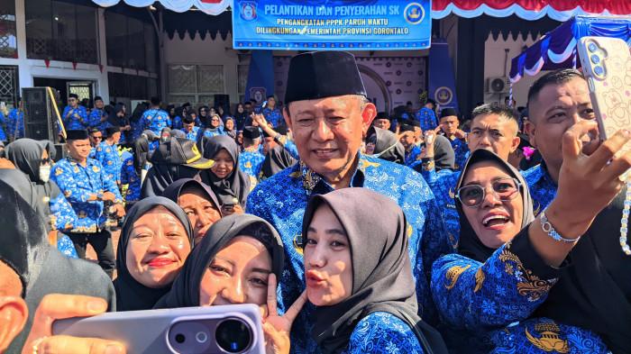 PELANTIKAN PPPK PARUH WAKTU -- Gubernur Gorontalo, Gusnar Ismail, dikerumuni pegawai seusai pelantikan 2.459 PPPK paruh waktu di halaman UPTD Museum Purbakala Gorontalo, Jumat (17/10/2025). Usai upacara, Gusnar tampak ramah meladeni permintaan foto dari para pegawai yang baru saja dilantik.