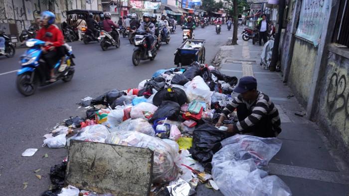 Kendaraan bermotor melintas di samping tumpukan sampah di pinggir Jalan Cibaduyut Raya, Kota Bandung, Jawa Barat, Rabu (30/7/2025).