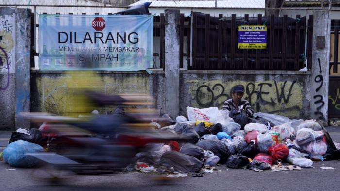 Kendaraan bermotor melintas di samping tumpukan sampah di pinggir Jalan Cibaduyut Raya, Kota Bandung, Jawa Barat, Rabu (30/7/2025).