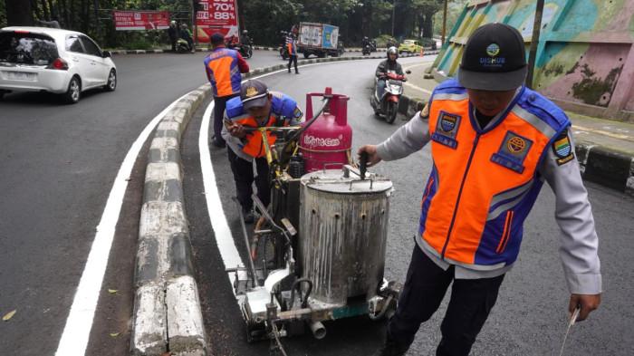 Petugas Dinas Perhubungan (Dishub) Kota Bandung membuat marka jalan berupa garis utuh dengan cat warna putih di tengah permukaan Jalan Siliwangi, Kota Bandung, Jawa Barat, Kamis (21/8/2025).