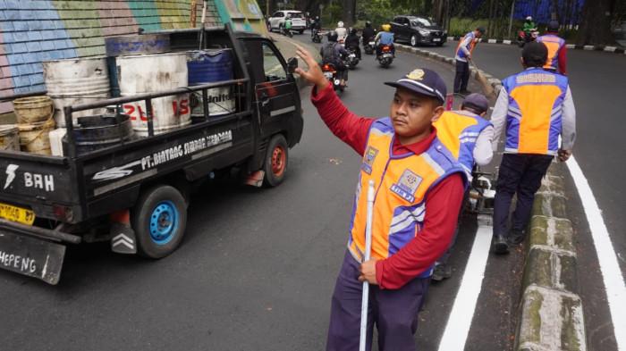 Petugas Dinas Perhubungan (Dishub) Kota Bandung membuat marka jalan berupa garis utuh dengan cat warna putih di tengah permukaan Jalan Siliwangi, Kota Bandung, Jawa Barat, Kamis (21/8/2025).