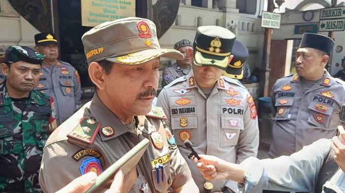 BERI KETERANGAN - Kasatpol PP Kabupaten Cirebon, Imam Ustadi, saat memberikan keterangan terkait penertiban pengemis di kawasan Makam Sunan Gunung Jati, Kabupaten Cirebon, Jawa Barat, Selasa (5/8/2025). Sebelumnya beredar video ada pemaksaan sedekah kepada peziarah.