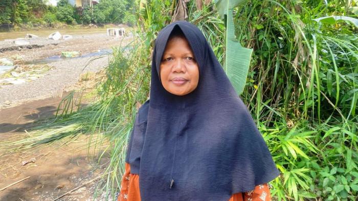 KELUARGA PEKERJA: Sumiati, warga Desa Penaruban yang merupakan seorang kerabat dari tiga pekerja yang dinyatakan hilang akibat banjir bandang yang terjadi di Sungai Klawing Purbalingga Minggu (3/8/2025) malam. Sumiati dijumpai saat sedang memantau perkembangan pencarian pekerja di sekitar lokasi kejadian, Senin (4/8/2025).