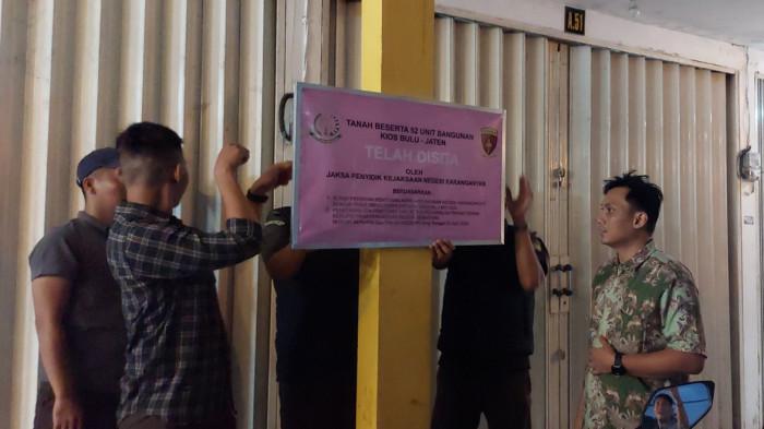 PENYITAAN KIOS - Pihak Kejari Karanganyar memasang papan informasi penyitaan terhadap 52 kios di atas tanah bengkok yang pembangunan dan sewanya bermasalah wilayah Desa/Kecamatan Jaten Kabupaten Karanganyar pada Senin (4/8/2025) petang.
