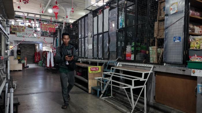 KIOS TUTUP - Seorang pria melintasi lorong kios yang tutup di Pasar Johar Tengah.