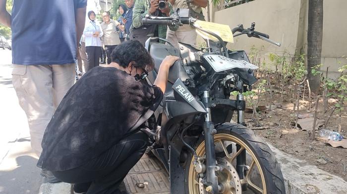 MENABUR MINYAK- Ingrid Suryani ibu dari Iko Juliant Junior mahasiswa Unnes yang disebut meninggal kecelakaan di Jalan Veteran Semarang sebelah Mapolda Jateng menaburkan minyak urapan dari Jerusalem ke motor Iko.