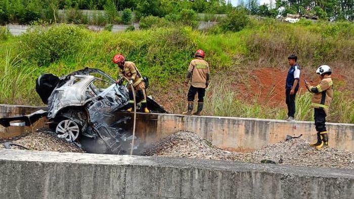 PADAMKAN API - Petugas memadamkan api yang membakar mobil setelah kecelakaan di ruas Tol Casumdawu, Jatinangor, Kabupaten Sumedang, Senin (13/10/2025/ siang. Satu orang meninggal dunia dalam insiden ini. (UPT Damkar Sumedang Kota untuk Tribun Jabar)