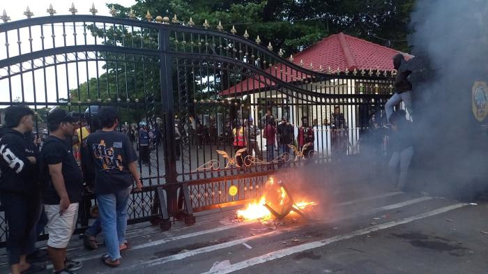 MEMBAKAR FOTO - Massa membakar foto Sudewo dan sebuah kursi di gerbang Kantor Bupati Pati, Jumat (31/10/2025).