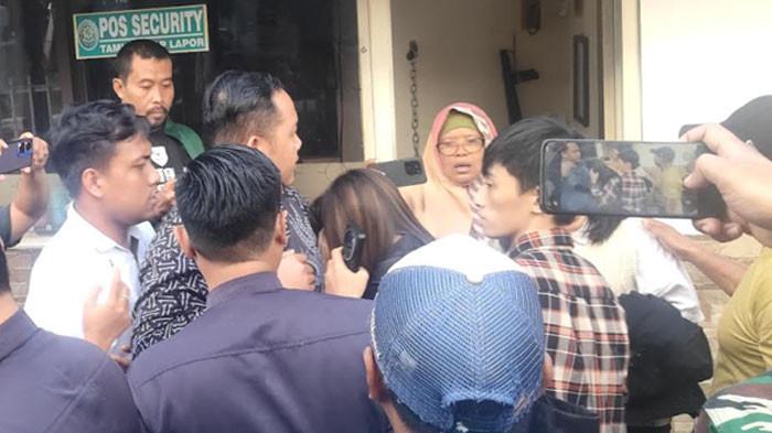 DIKEPUNG USAI SIDANG — Elok Dwi Kadja, pengacara Diana, menangis di depan pos satpam Pengadilan Negeri Surabaya setelah diteriaki dan dicecar massa usai persidangan, Rabu (6/8). Ia mengaku hanya menjalankan tugas profesi sebagai advokat.