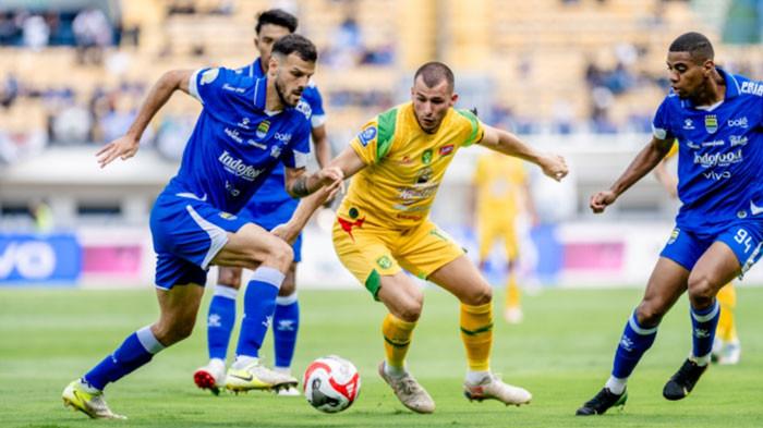 Striker asing Persebaya, Mihailo Perovic berduel dalam perebutan bola dengan pemain Persib Bandung di Stadion Gelora Bandung Lautan Api, Jumat (12/9/2025) sore. Laga dihentikan menit 70 dengan kedudukan 1-0 untuk Persib.