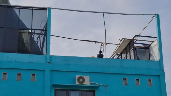 ATAP TERBANG- Kondisi Politeknik Kaltara berlokasi di Kelurahan Kampung Satu, Tarakan Kalimantan Utara pasca insiden atap seng aula terbang dan jendela rusak, Kamis (9/10/2025). Dosen gotong royong lakukan pembersihan gedung.