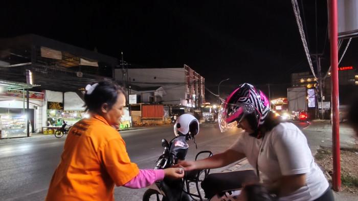 JURU PARKIR - Herlina Wati juru parkir perempuan di Kota Kupang sedang bekerja.