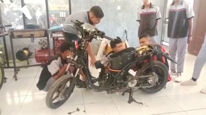 Para guru dan siswa-siswi SMK Negeri Oeolo merancang sepeda motor