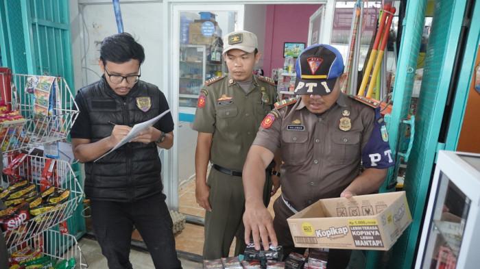 SITA ROKOK ILEGAL - Petugas Bea Cukai Malili bersama Satpol PP Luwu memeriksa kios di Kecamatan Belopa dan Bajo, Kabupaten Luwu, Sulawesi Selatan, dalam Operasi Pasar Pemberantasan Rokok Ilegal 2025, Senin (6/10/2025). Sebanyak 75 slop atau 15 ribu batang rokok ilegal tanpa pita cukai disita.