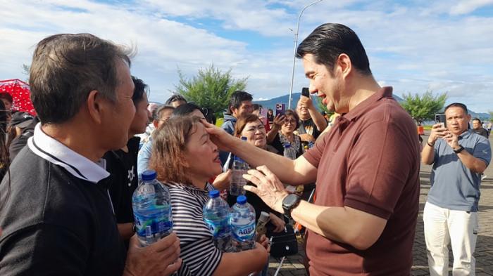 PENYEMBUHAN - Pastor Andi Simon melakukan penyembuhan terhadap warga di Kawasan Pohon Kasih, Mega Mas, Kelurahan Wenang, Kecamatan Wenang, kota Manado, provinsi Sulawesi Utara, Minggu (26/10/2025) sore.