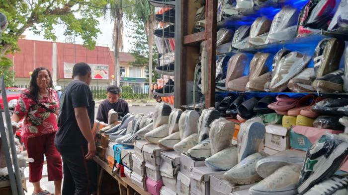 PENJUAL SEPATU - Penjual sepatu KW di Pasar 45, Manado, Sulawesi Utara, Jumat (24/10/2025). Ia mengaku tak memasok barang ke mall.
