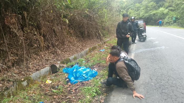 KORBAN KECELAKAAN - Kondisi pengendara sepeda motor meninggal dunia dan ditutupi mantel oleh teman korban pasca tabrakan dengan mobil box di Hutan Lae Pondom Kecamatan Sumbul Kabupaten Dairi.