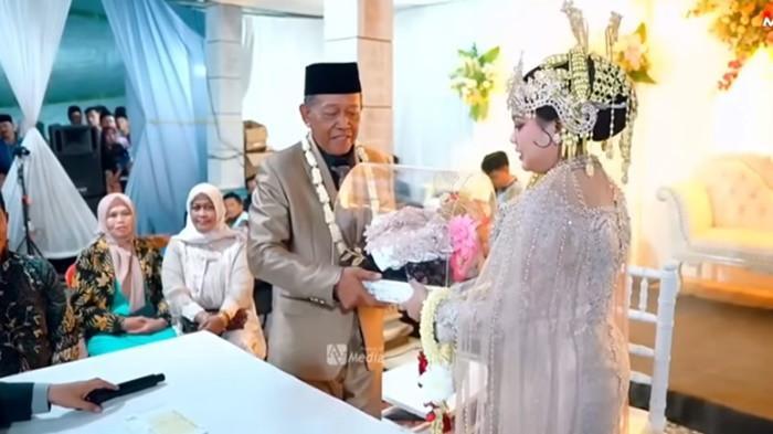 PERNIKAHAN VIRAL - Momen pernikahan kakek Tarman (74), dengan Sheila Arika (24), warga asal Desa Jeruk, Kecamatan Bandar, Kabupaten Pacitan, Jawa Timur. KUA Bandar, angkat bicara terkait viralnya pernikahan kakek Tarman (74) dengan Sheila Arika (24), gadis di pacitan yang diberi mahar cek Rp3 miliar