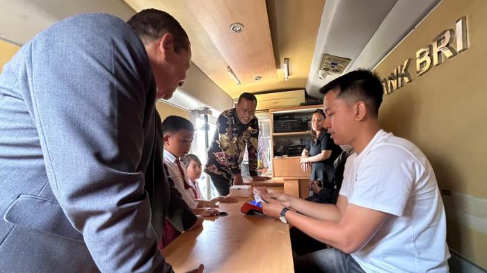 Ketua DPD PDIP Sumatera Utara sekaligus anggota Komisi XIII DPR RI, Drs. Rapidin Simbolon, MM, bersama Bupati Toba Efendy Napitupulu meninjau simulasi pencairan beasiswa bagi pelajar dan orang tua di dalam mobil gerai Bank BRI, Sabtu (25/10/2025). Beasiswa senilai Rp309 juta itu diberikan kepada 635 pelajar SD dan SMP kurang mampu namun berprestasi di Kabupaten Toba.