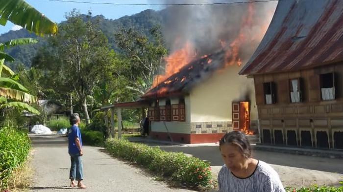 KEBAKARAN RUMAH: Pemilik rumah terlihat pingsan dan dibantu oleh masyarakat sekitar setelah melihat rumahnya yang terbakar di Jorong Solok Baruah, Nagari Salo, Kecamatan Baso, Kabupaten Agam, Selasa (21/10/2025). Saksi mata, Serli sebut kebakaran diduga terjadi sekira pukul 08:45 WIB.
