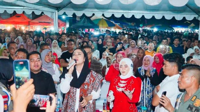 SUASANA SEMARAK HUT RI -Ribuan masyarakat tumpah ruah memadati Halaman Kantor Bupati Dharmasraya, menyaksikan konser istimewa Fauzana dalam rangkaian perayaan HUT ke-80 Kemerdekaan Republik Indonesia, Minggu (17/8/2025) malam. Pada kesempatan sama, Bupati Annisa turut larut melantunkan vokalnya sambil berduet maupun nyanyi solo yang menarik perhatian warga yang hadir saat itu.