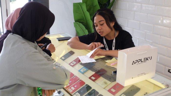 LAYANI PEMBELI - Pramuniaga melayani pembeli iPhone yang berbelanja di Appleku Store, di Jalan MT Haryono Nomor 78, Lingkungan Pandean, Kelurahan Temanggung II, Kecamatan/Kabupaten Temanggung, Jawa Tengah. Berikut daftar harga pasaran iPhone bekas di Solo.