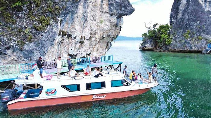 Speed boat mengangkut rombongan pelancong di spot wisata Kabupaten Raja Ampat, Papua Barat Daya.