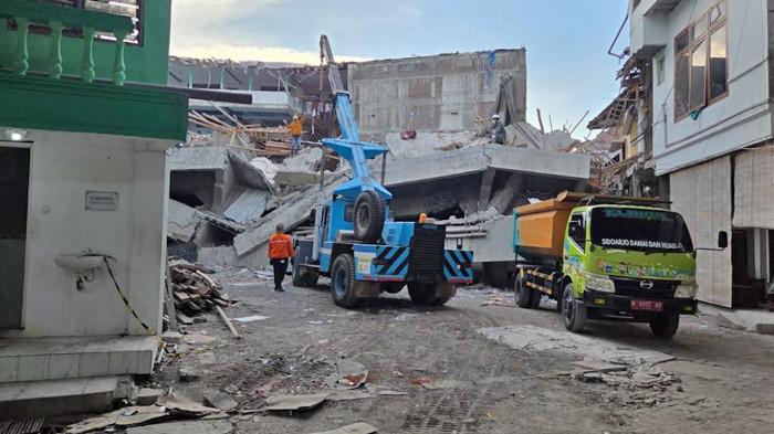 PINDAHKAN PUING - Tim SAR gabungan fokus melakukan pemindahan material atau puing-puing bangunan Ponpes Al Khoziny Sidoarjo yang runtuh setelah mengerahkan alat berat ke lokasi, Kamis (2/10/2025) siang. Hingga Kamis malam ini, proses itu terus berjalan, di mana balok beton, plat, dan berbagai puing reruntuhan terus dipindahkan dari lokasi.