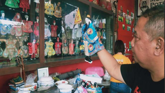WAYANG POTEHI - Toni Harsono, pendiri museum sekaligus Ketua Klenteng Hong San Kiong saat menunjukkan salah satu karakter wayang potehi di Museum Potehi Gudo, Desa Gudo, Kecamatan Gudo, Kabupaten Jombang, Jawa Timur, Sabtu (1/11/2025). Kesenian Potehi sudah tumbuh di Gudo sejak tahun 1920-an, dibawa oleh para perantau dari Tiongkok