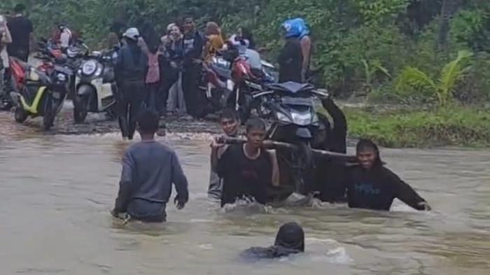 BENCANA: Tampak motor digorong untuk bisa melewati banji di salah satu jalan di Desa Beringin Jaya, Kecamatan Taliabu Barat Laut, Maluku Utara banjir, Sabtu (6/9/2025)