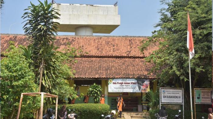SEKOLAH DILINTASI PROYEK TOL - Bangunan Sekolah Dasar Negeri (SDN) Burangkeng 04, Kecamatan Setu, Kabupaten Bekasi, dilintasi proyek pembangunan ruas Jalan Tol Jakarta-Cikampek (Japek) Selatan seperti terlihat Kamis (24/7/2025). Pembangunan jalan tol yang berdekatan dengan lingkungan sekolah menimbulkan dampak serius terhadap keamanan, kenyamanan, dan kelangsungan pendidikan di sekolah tersebut.