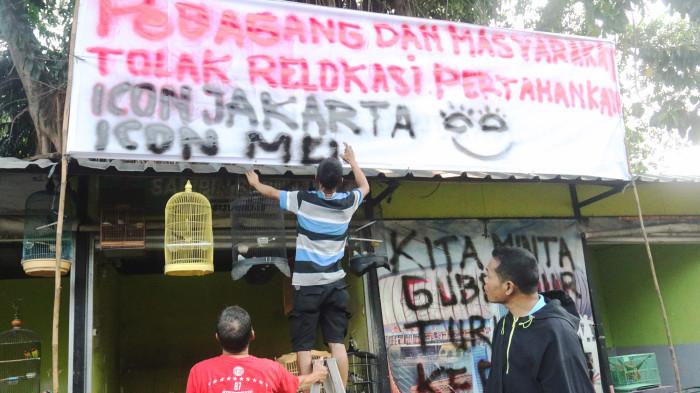 PENOLAKAN RELOKASI - Sejumlah pedagang memasang spanduk penolakan relokasi di Pasar Barito, Kebayoran Baru, Jakarta Selatan, Selasa (5/8/2025). Salah satu alasan kuat penolakan pedagang adalah lokasi baru yang masih berupa lahan kosong. Warta Kota/Yulianto