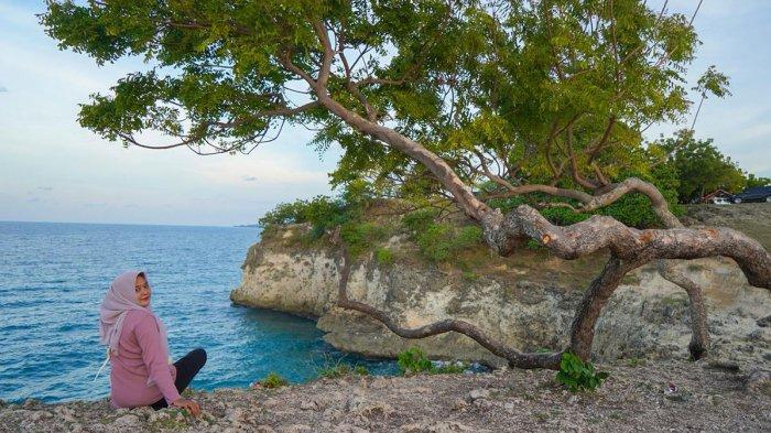 BUKIT LAMREH - Seorang pengunjung foto dengan latar tebing dan laut Lamreh, Aceh Besar, Selasa (18/11/2025). Kawasan ini menjadi salah satu spot favorit wisatawan untuk berfoto dan bersantai.