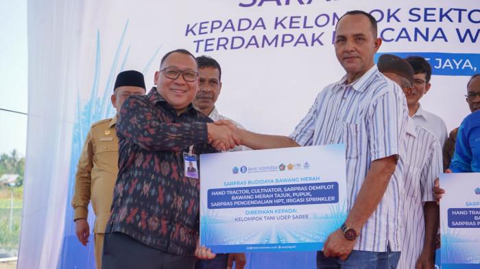 Kepala Bank Indonesia (BI) Perwakilan Provinsi Aceh Agus Chusaini (tengah) berfoto bersama penerima bantuan sarana dan prasarana usai penyerahan bantuan kepada kelompok pertanian, kelompok garam dan lembaga pendidikan di Kabupaten Pidie dan Pidie Jaya, Selasa (7/7). Bantuan ini merupakan bagian dari upaya BI Aceh dalam mendukung percepatan pemulihan ekonomi masyarakat pascabencana melalui penguatan sektor pertanian dan pendidikan.