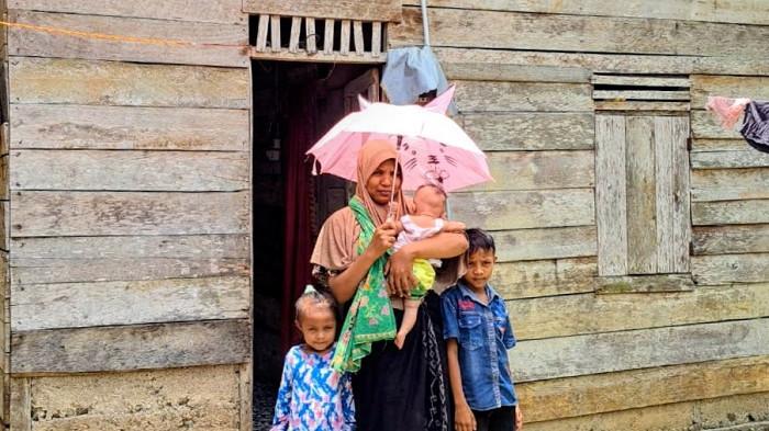 ASA NURLAILA - Nurlaila dan tiga anaknya berfoto di depan rumah mereka, di di Dusun Alue Badeuk, Gampong Cot Mane, Kecamatan Jeumpa, Kabupaten Aceh Barat Daya (Abdya), Senin (13/4/2026).