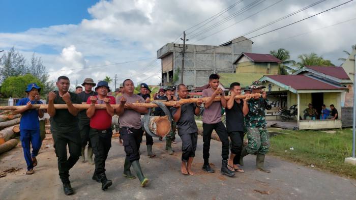 BANGUN JEMBATAN DARURAT - Angkat Batang Kelapa: Personel gabungan mengangkat batang kelapa untuk membuat jembatan darurat di ruas jalan menuju Singkil, ibu kota Kabupaten Aceh Singkil, di Desa Gosong Telaga Barat, Kecamatan Singkil Utara, Selasa (16/12/2025).