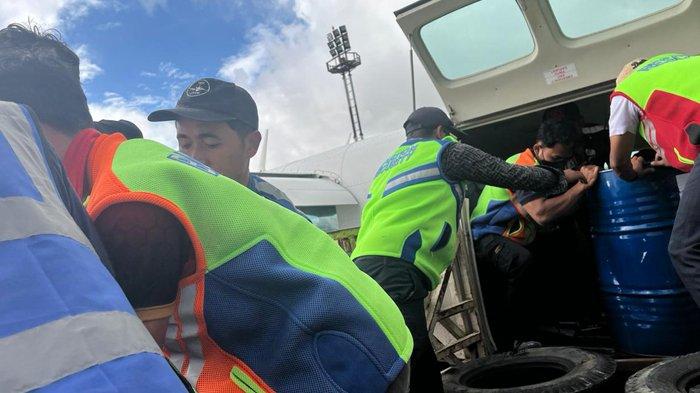 TURUNKAN BBM - Petugas di Bandara Rembele Bener Meriah menurunkan BBM yang dipasok oleh Pertamina Patra Niaga, Kamis (4/12/2025). Dalam penyaluran tahap awal ini, Pertamina Patra Niaga mengirimkan 1.000 liter Pertalite (setara 5 drum) dan 1.000 liter Biosolar (setara 5 drum).