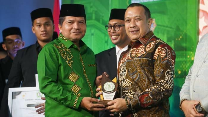 SERAHKAN PENGHARGAAN - Dewan Pembina ISAD Aceh yang juga Ketua MPU Aceh, Tgk H Faisal Ali menyerahkan penghargaan kategori Mitra Strategis ISAD Aceh kepada Pemimpin Serambi Indonesia, Zainal Arifin M Nur dalam acara pengukuhan pengurus ISAD Aceh periode 2025-2030 di Aula MPU Aceh, Sabtu (2/5/2026) malam.