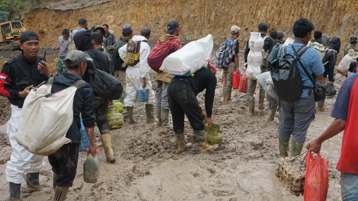 Warga berasal dari Kabupaten Bener Meriah dan Aceh Tengah menempuh jarak puluhan kilometer dengan berjalan kaki melewati jalan lintasan KKA (Bener Meriah-Aceh Utara), Selasa (16/12/2025). Dok Bustami/Tribun Gayo