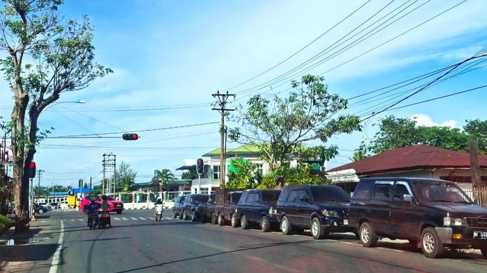 ANTRE BBM - Sejumlah mobil antre sampai lampu merah demi mendapatkan BBM di SPBU di jalan Manekroo, Meulaboh, Aceh Barat, Kamis (18/9/2025).