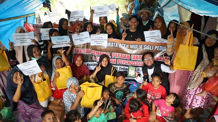 FOTO BERSAMA - Penyanyi Bergek, Pembina Yayasan Permata Aceh Mulia ( YPAM ) Sigli, Mahfuddin Ismail, MAP bersama Bunda Hetti saat mengunjungi dan memberi dukungan di pengungsian di kecamatan Langkahan Kabupaten Aceh Utara. Kamis, 25 Desember 2025.