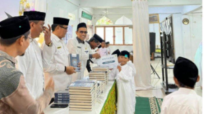Staf Ahli Wali Kota Banda Aceh, H Ridwan Ibrahim, M.Pd, bersama Kepala Dinas Syariat Islam Banda Aceh Alimsyah, S.Pd, M.Si, Imam Gampong Lambaro Skep, Tuha Peut, serta Direktur TPQ HU saat pengukuhan peserta tahfidz dan penyerahan sertifikat/piagam pada acara penutupan Daurah Tahfidz dan Tarbiyah Ramadhan 1447 H TPQ Hidayatul Ulum Lambaro Skep, yang berlangsung di Aula Gedung Dayah Terpadu Inshafuddin, Rabu, 11 Maret 2026.