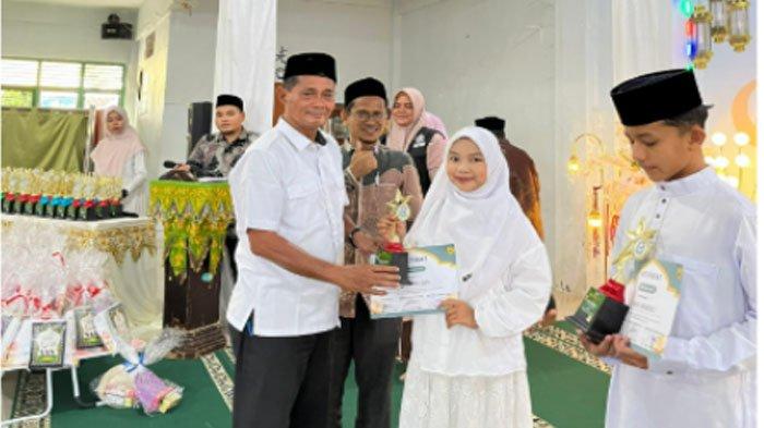 Keuchik Gampong Lambaro Skep Ir Mukhlis Ja'far MM didampingi Direktur TPQ HU menyerahkan sertifikat/piagam pada acara penutupan Daurah Tahfidz dan Tarbiyah Ramadhan 1447 H TPQ Hidayatul Ulum Lambaro Skep, yang berlangsung di Aula Gedung Dayah Terpadu Inshafuddin, Rabu, 11 Maret 2026.