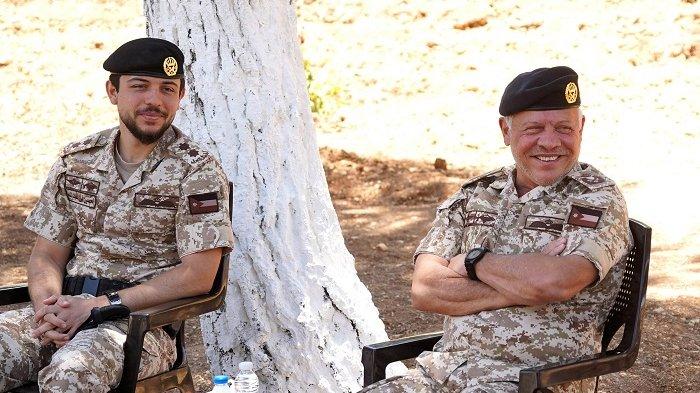 Pangeran Hussein (kiri) duduk bersama ayahnya Raja Abdullah saat melakukan pertemuan dengan para komandan militer dan pejabat sipil tentang pencegahan virus Corona di Jordania pada 30 Juni 2020.